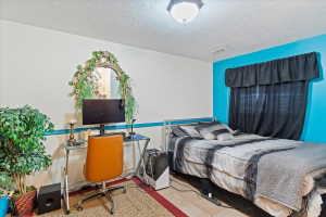 Bedroom featuring a paneled ceiling with flush-mount lighting, two-tone wall design, and tile flooring