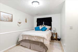 Bedroom featuring tile flooring, white walls, and a chair rail molding