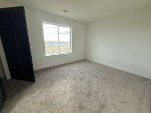 Spare room featuring baseboards and light colored carpet