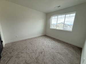 Empty room featuring light carpet and baseboards