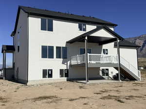 Rear view of property with a patio, stairs, a deck with mountain view, and stucco siding