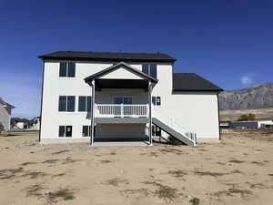 Rear view of property featuring stairs, a deck with mountain view, and a patio area