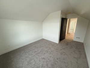 Bonus room featuring carpet floors and vaulted ceiling