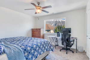Carpeted bedroom featuring visible vents, baseboards, and ceiling fan