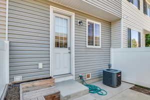 Entrance to property with central AC and fence