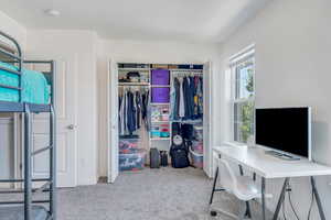 Carpeted bedroom featuring a closet