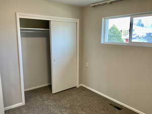 Unfurnished bedroom featuring visible vents, a closet, baseboards, and carpet floors