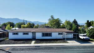 Ranch-style home featuring a mountain view, concrete driveway, and an attached garage