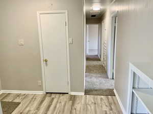 Hall featuring visible vents, baseboards, and light wood finished floors