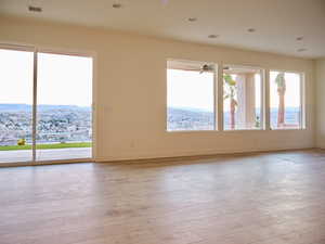 Spare room featuring light wood-style floors, visible vents, and baseboards