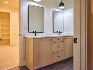 Bathroom featuring tile patterned floors, double vanity, and a sink
