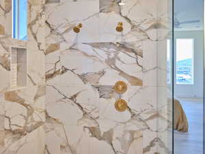 Details featuring wood finished floors and a marble finish shower