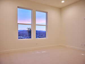 Carpeted spare room featuring a mountain view, baseboards, and recessed lighting