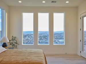 Bedroom featuring light wood-style flooring, visible vents, and recessed lighting