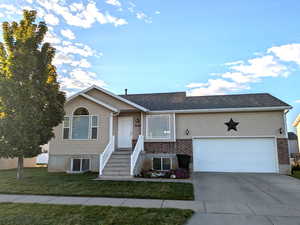Ranch-style home featuring driveway, a front yard, an attached garage, and brick siding