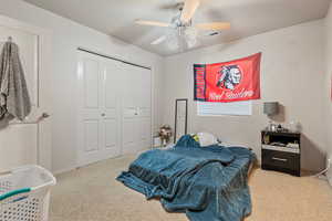 Carpeted bedroom with baseboards, a closet, and ceiling fan