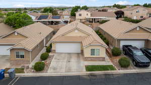 View of front of house with stucco siding, a tile roof, a residential view, and concrete driveway