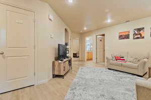 Living room featuring baseboards, light wood finished floors, visible vents, and recessed lighting