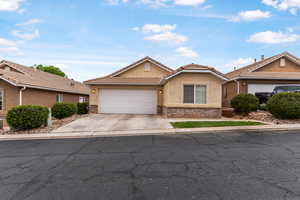 Ranch-style house featuring a garage, a tile roof, driveway, and stucco siding