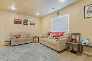 Living room featuring light wood-style flooring, visible vents, and baseboards