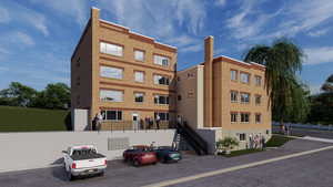 View of building exterior with stairs and fence