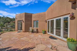 Back of house with french doors, a patio, and stucco siding