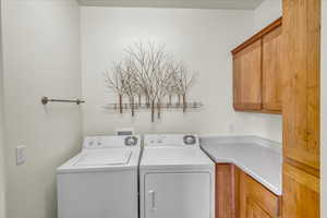Laundry room with cabinet space and washer and clothes dryer