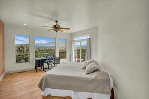 Bedroom featuring visible vents, baseboards, ceiling fan, light wood finished floors, and access to exterior