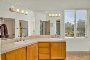 Full bathroom featuring tile patterned floors, double vanity, a sink, and toilet