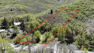 Aerial overview of property's location with a heavily wooded area and property parcel outlined