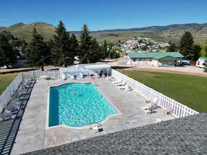 Pool featuring a mountain view, fence, and a patio