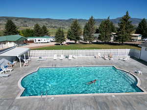 Pool with a patio area, fence, and a mountain view