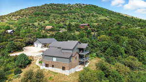 View from above of property featuring a heavily wooded area and a mountainous background