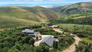 Aerial view of property and surrounding area featuring a mountainous background