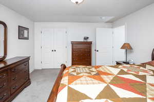 Bedroom with light carpet and a closet