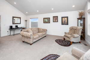 Carpeted living room with visible vents, baseboards, lofted ceiling, and recessed lighting