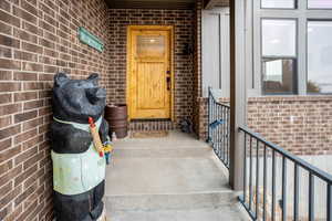 Doorway to property featuring brick siding