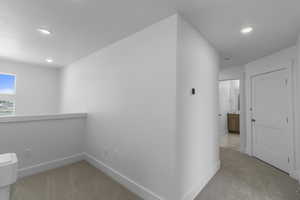 Hall with recessed lighting, carpet floors, and baseboards