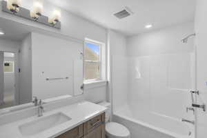 Full bathroom featuring washtub / shower combination, visible vents, toilet, recessed lighting, and vanity
