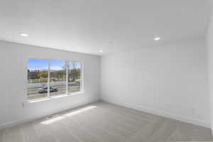 Carpeted empty room with recessed lighting, visible vents, and baseboards