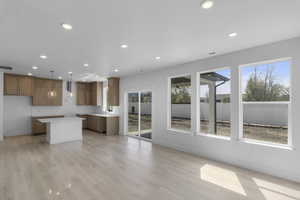 Interior space with a sink, visible vents, baseboards, light wood-type flooring, and recessed lighting