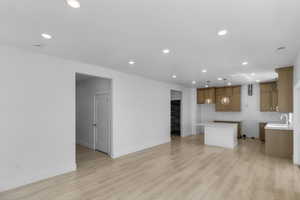 Kitchen featuring recessed lighting, a sink, brown cabinetry, and light wood-style floors