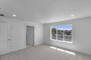 Carpeted spare room featuring baseboards, visible vents, and recessed lighting