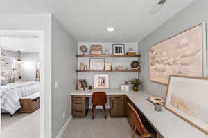 Office area featuring baseboards, built in desk, recessed lighting, visible vents, and light colored carpet