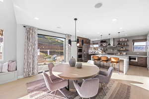 Dining room with light wood-style floors, a healthy amount of sunlight, and recessed lighting
