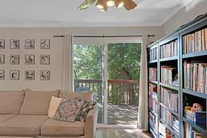 Interior space with ornamental molding, ceiling fan, and wood finished floors