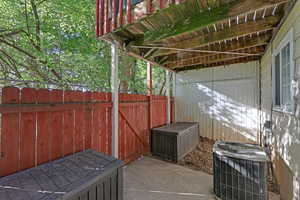 View of patio with fence and central AC unit