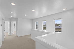 Hall with visible vents, recessed lighting, light carpet, and baseboards