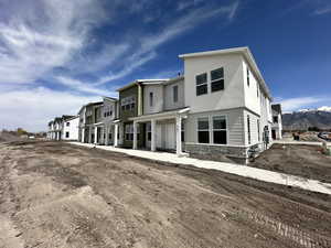 Back of property with a residential view, a mountain view, and stone siding