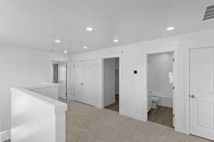 Hallway with recessed lighting, carpet flooring, an upstairs landing, visible vents, and baseboards